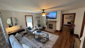 A living room with a fireplace, a sofa, a coffee table, and a television.