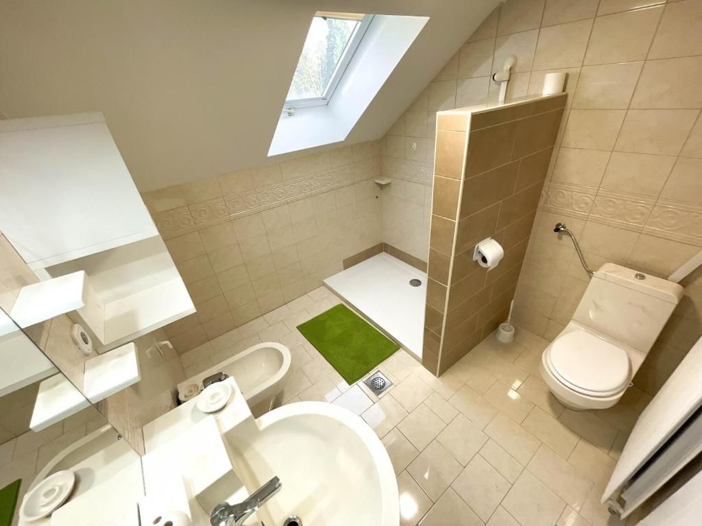 Une salle de bain moderne avec un puits de lumière, une baignoire, des toilettes et un lavabo.