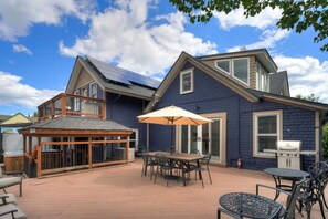 Ein Haus mit Terrasse, überdachter Veranda und Grillplatz.