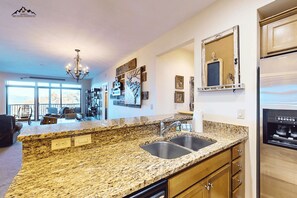 A kitchen with granite countertops, a double sink, and wooden cabinets. - Luxury 2 Bedroom Sugar Mountain Condo with Gas Log Fireplace and Huge Deck (Sugar Mountain)