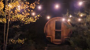 Estrutura de madeira com porta, rodeada por folhagem e luzes de cordão.