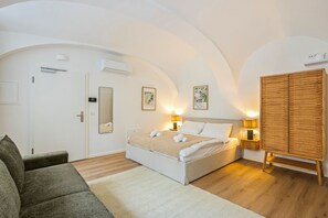 Ein Schlafzimmer mit einem Bett, Nachttischlampen, einem Kleiderschrank und einem Sofa.