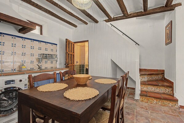 A dining area with a wooden table, chairs, and woven placemats.
