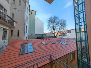 A multi-story building with a red-tiled roof and multiple windows. - Modern 1BR in trendy Žižkov (Praha 3)
