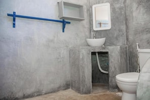 Een badkamer met een wit wastafelmeubel, toilet en douchecabine.