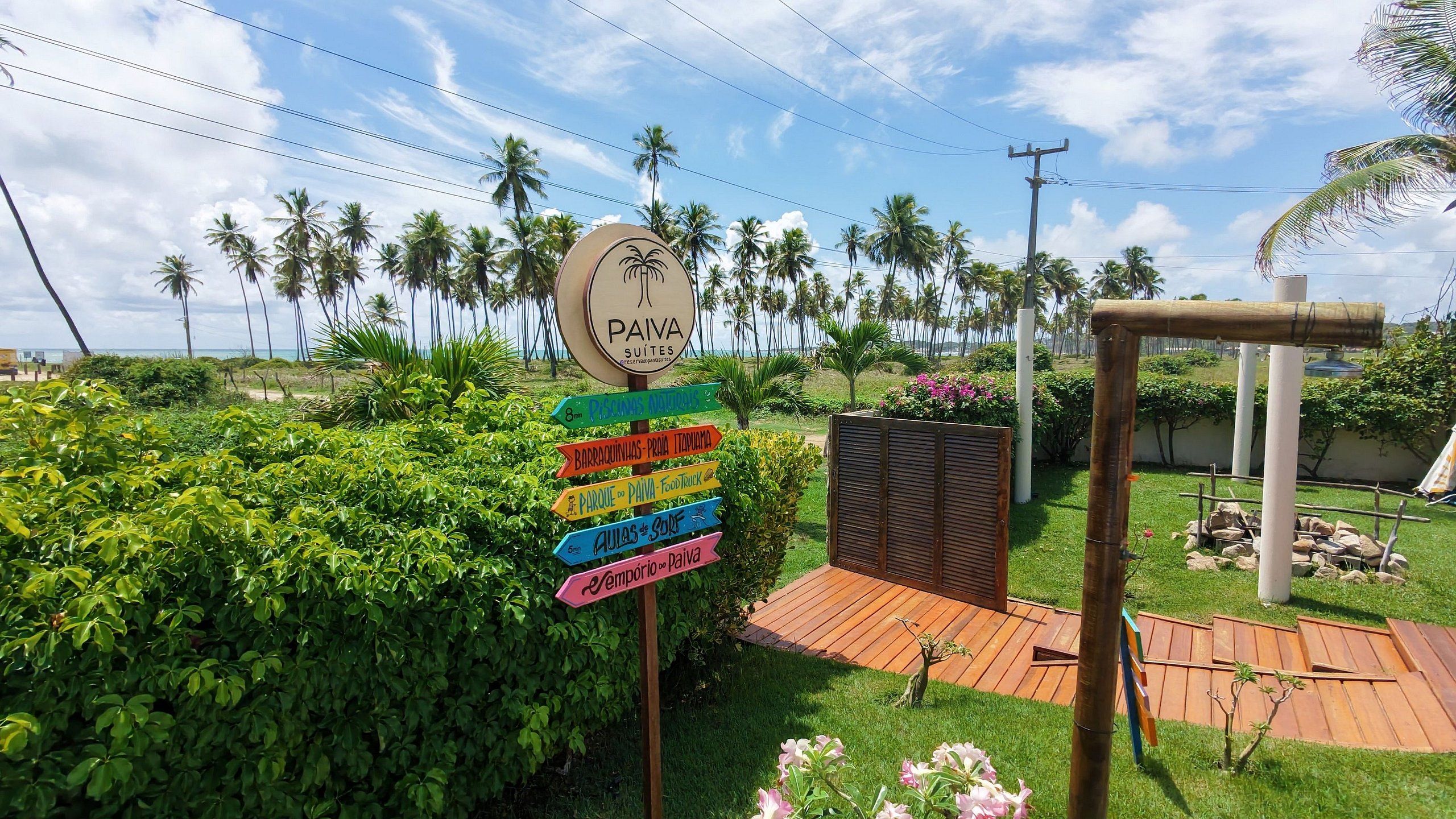 A signpost with directions to various amenities including a pool, beach, and park, with a tropical backdrop.