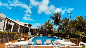 A poolside area with lounge chairs and a wooden deck.