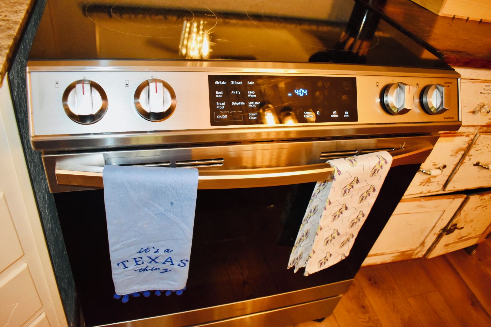 A stainless steel oven with a digital control panel displaying various cooking functions.