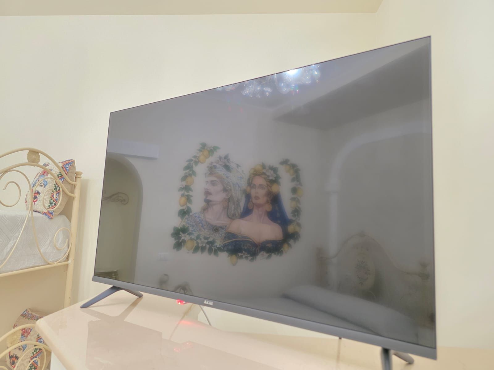 Un televisore montato su un supporto con un oggetto decorativo a sinistra.