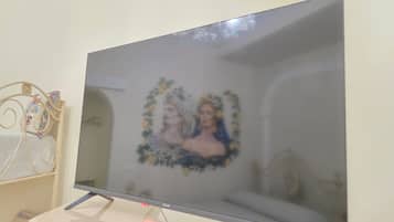 Un televisore montato su un supporto con un oggetto decorativo a sinistra.