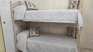 A bunk bed with two pillows, each featuring a face design.
