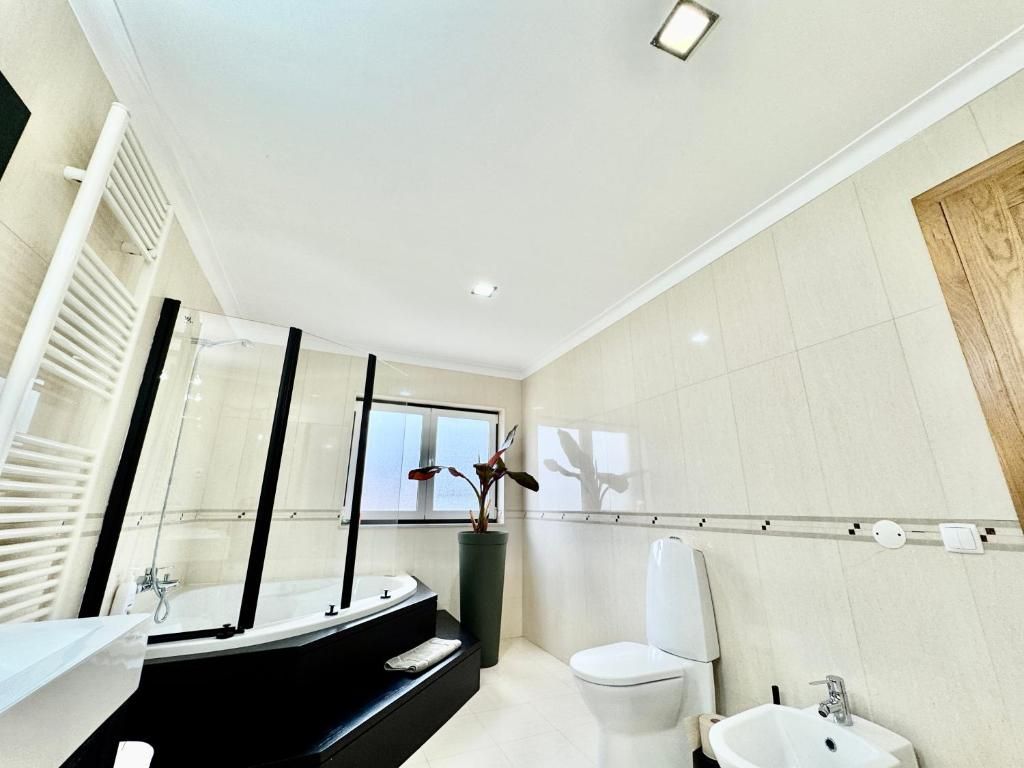 Une salle de bain moderne avec une baignoire, des toilettes et un lavabo.
