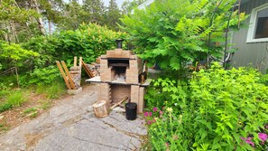 A brick outdoor oven in a garden setting. - Luxury Cottage - Detox & Relaxation (Stone Mills)