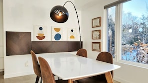 A modern dining area with a white table, brown chairs, and abstract wall art. - Luxury Cottage - Detox & Relaxation (Stone Mills)
