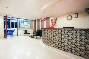 A reception area with a patterned wall, a reception desk, and a clock on the wall. - Hotel O Priya Residency (Hyderabad)