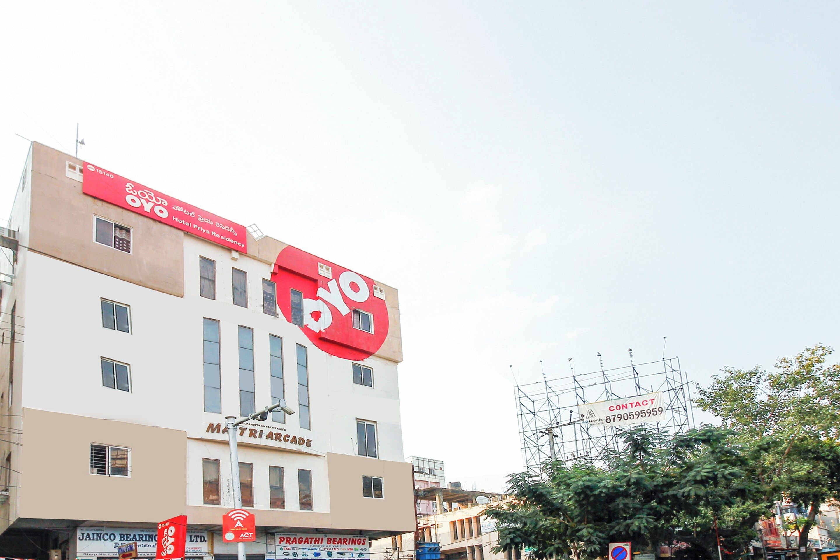 Un edificio de varios pisos con un letrero rojo grande en la parte superior.