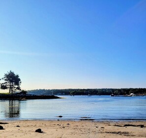 A calm lake with boats, a sandy beach, and a tree on the left. - Cozy Coastal Studio Cottage a short walk to Pemaquid Beach (Bristol)