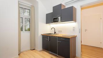 A modern kitchen with a built-in microwave, a sink, and a dishwasher.