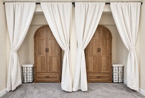 A room with two wooden wardrobes, a grey carpet, and white curtains tied back. - Upscale Two-Suite Denver Retreat - Sleeps 11 (Denver)