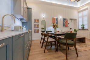 Een moderne keuken met een eethoek, met een centraal kookeiland, stoelen en een bank.
