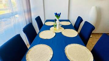 Un comedor con mantel azul, individuales tejidos y sillas azules.