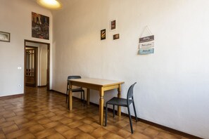 A room with a wooden table and two chairs, a door leading to another room, and a wall with framed pictures and motivational signs. - Borgo Tegolaio House by MMega Homes and Villas (Florence)