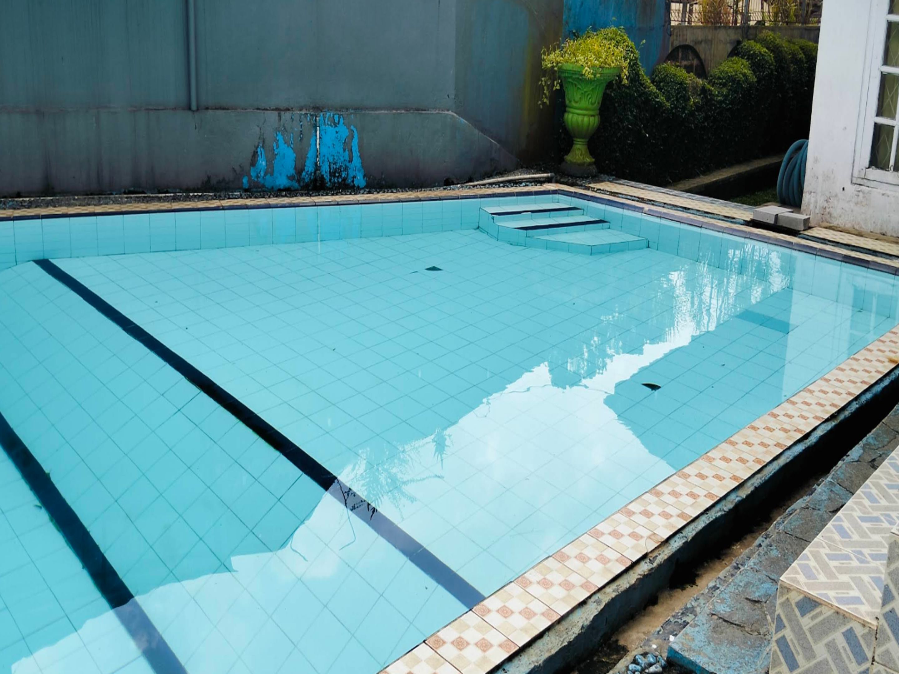 A swimming pool with tiled edges and a small entry point.