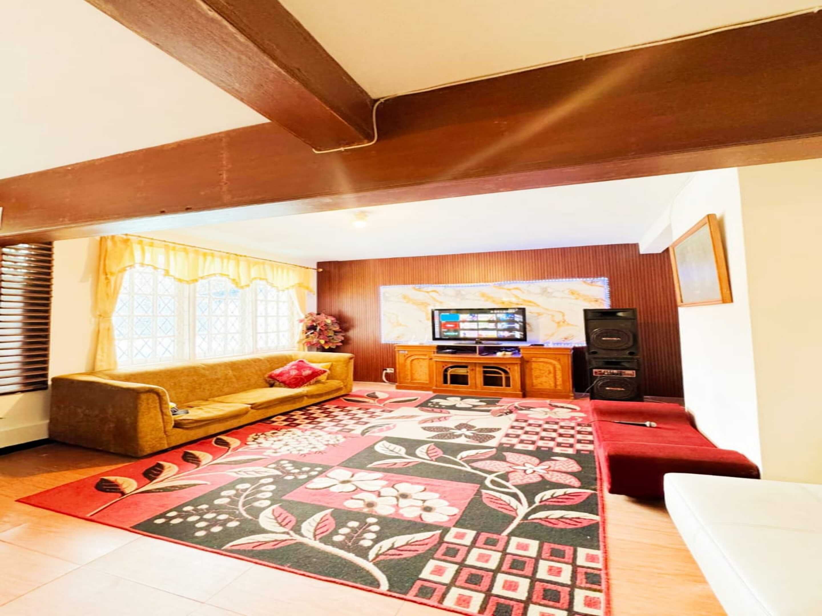 A living room with a sofa, a coffee table, a TV, and a speaker.