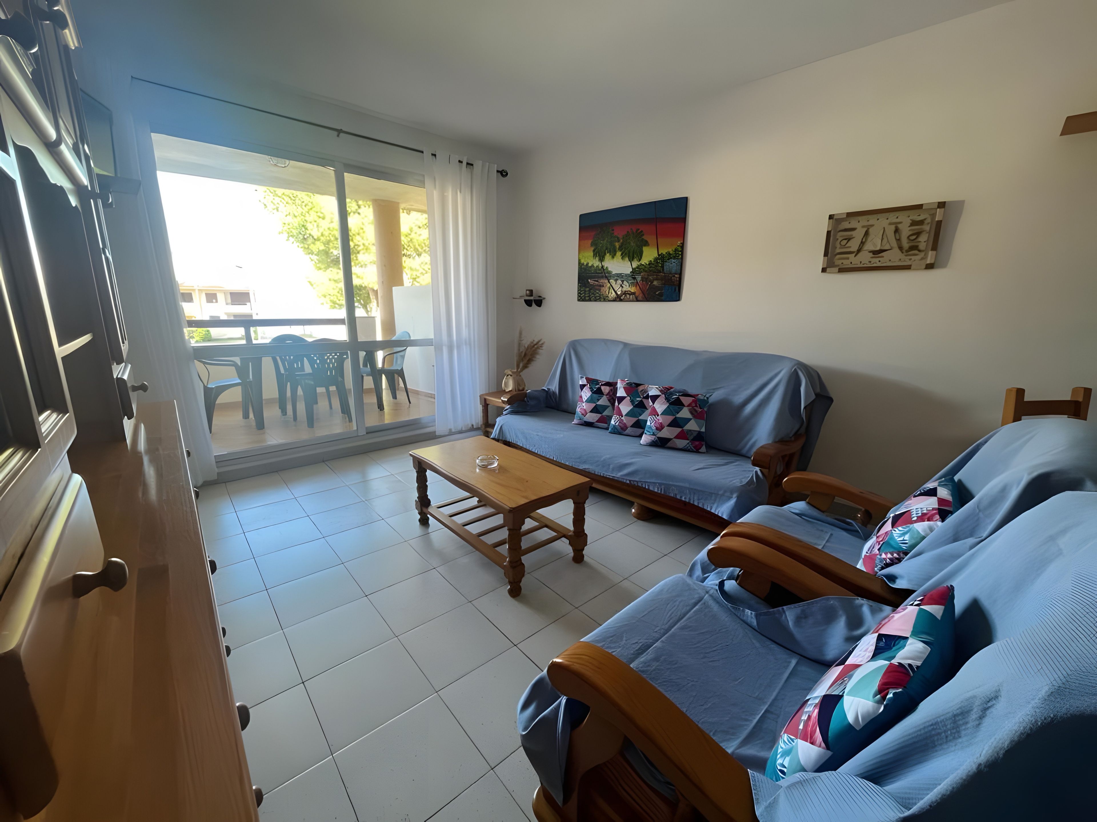 Sala de estar com sofá, mesa de centro e área de jantar com cadeiras e mesa.
