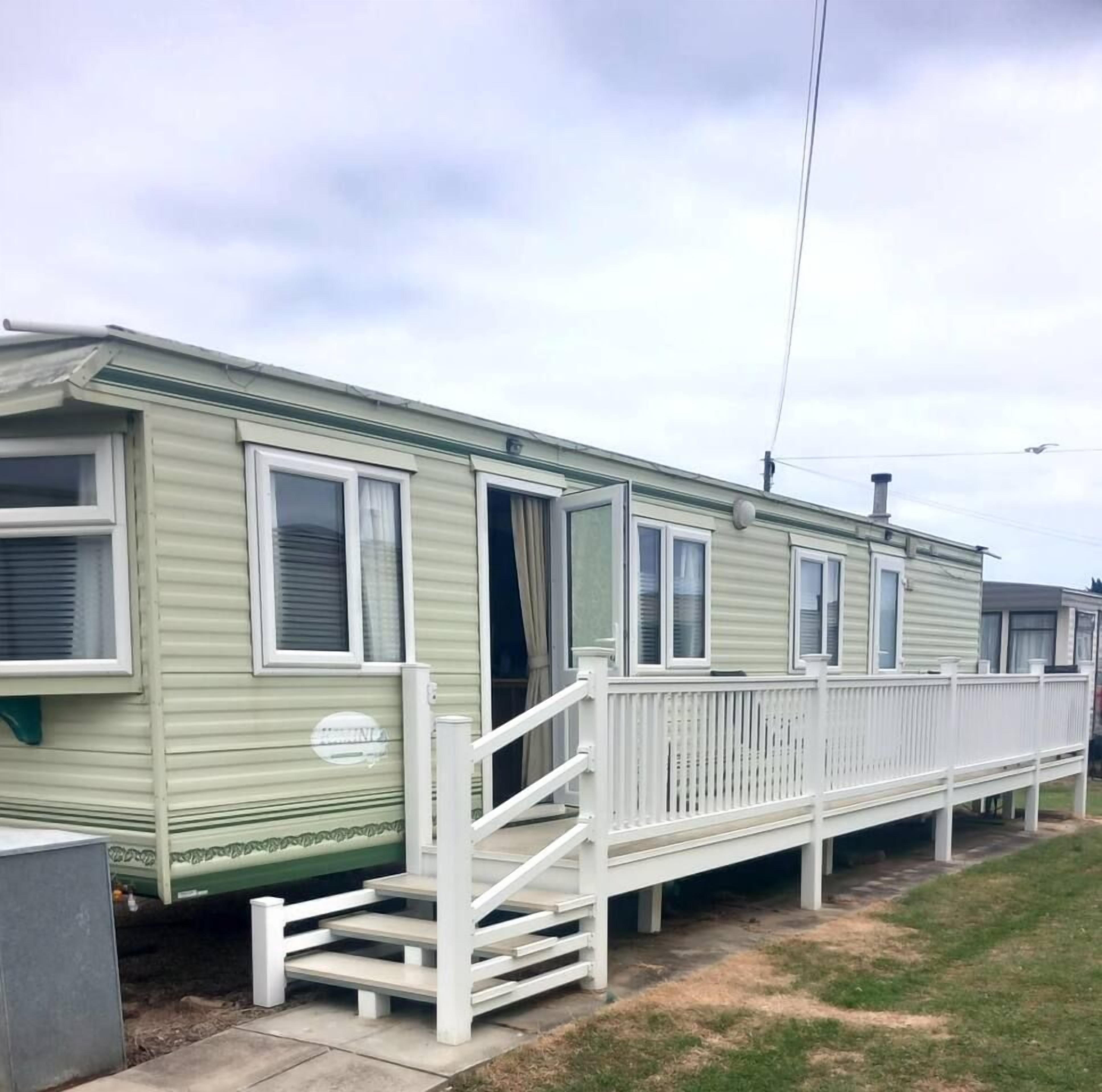 A row of mobile homes with white railings and a small porch area.