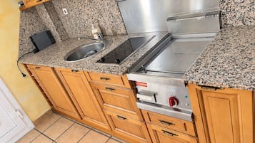 Una cocina con encimeras de granito, electrodomésticos de acero inoxidable y armarios de madera.