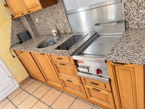 Eine Küche mit Granit-Arbeitsplatten, Edelstahlgeräten und Holzschränken.