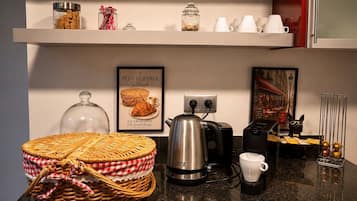 Een aanrecht met een koffiezetapparaat, een mand en een lijst met gerechten.