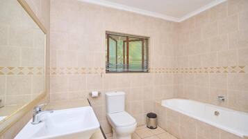 Un baño con inodoro, lavabo y bañera.
