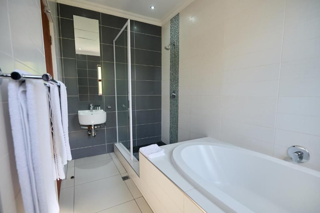 Un baño moderno con bañera, ducha y lavamanos.
