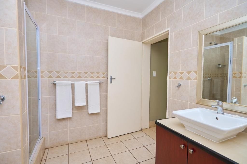 Un baño con ducha, lavabo y espejo.