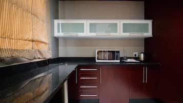 A compact kitchen with a microwave, cabinets, and a countertop.