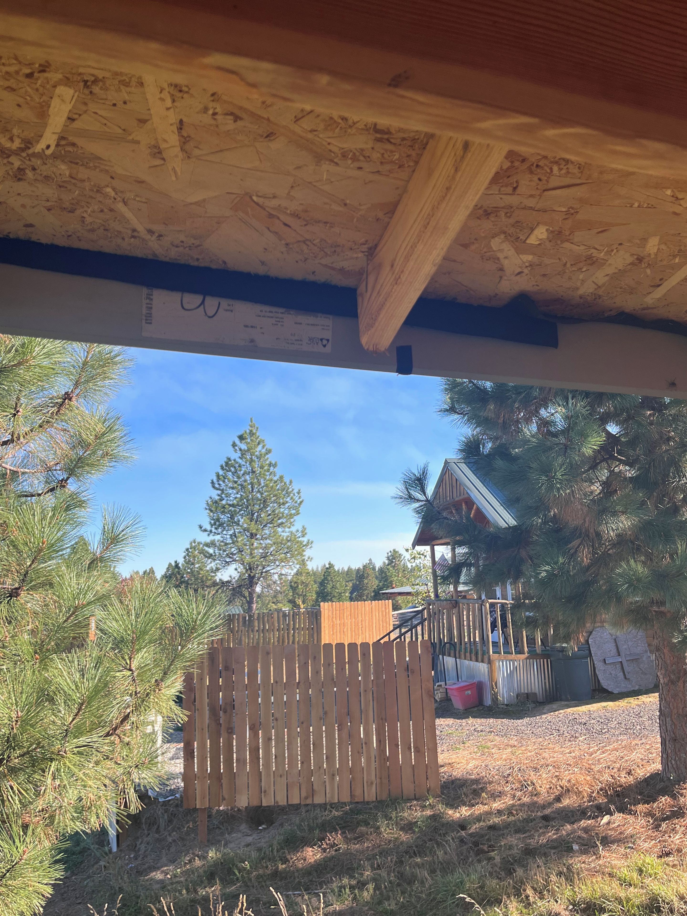 A wooden deck with a view of a building and trees.