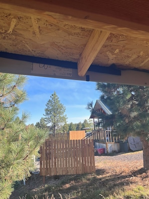 Una terraza de madera con vista a un edificio y árboles.