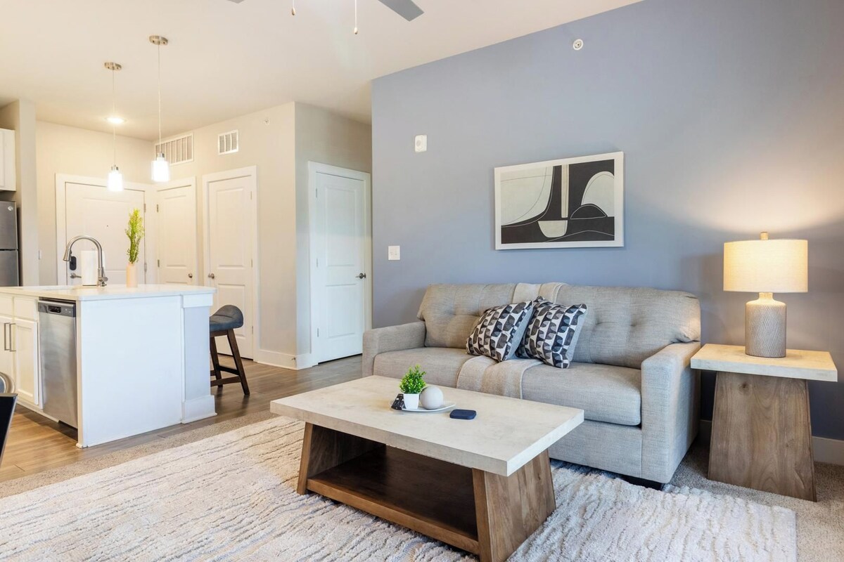 A modern living room with a sofa, coffee table, and a lamp.