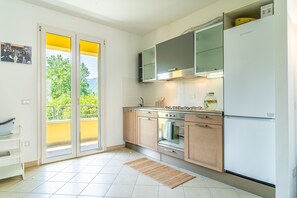 A modern kitchen with a built-in oven, a stove, and a refrigerator. - Holiday Home 'Alba Sunrise - Ac Hot Tub Parking' with Wi-Fi and Air Conditioning (Lucca)