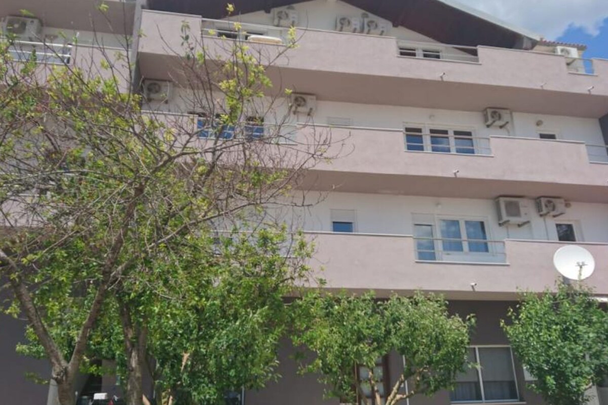 A multi-story building with balconies and air conditioning units.