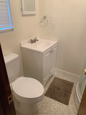 Ein Badezimmer mit Toilette, Waschbecken und Spiegel.