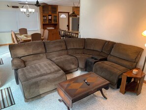Ein Ecksofa, ein Couchtisch und ein Essbereich mit Stühlen und einem Tisch.