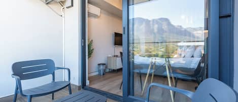 A balcony with two chairs, a small table, and a TV.