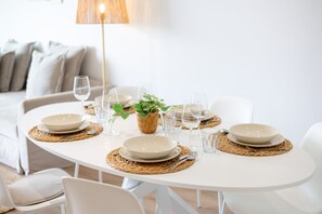 A dining table set with plates, glasses, and a potted plant. - Casa Azahar · Beautiful apartment in Villamartín (Orihuela Costa)