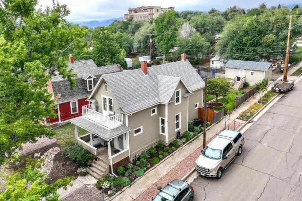 A residential area with houses, a driveway, and a parked car.