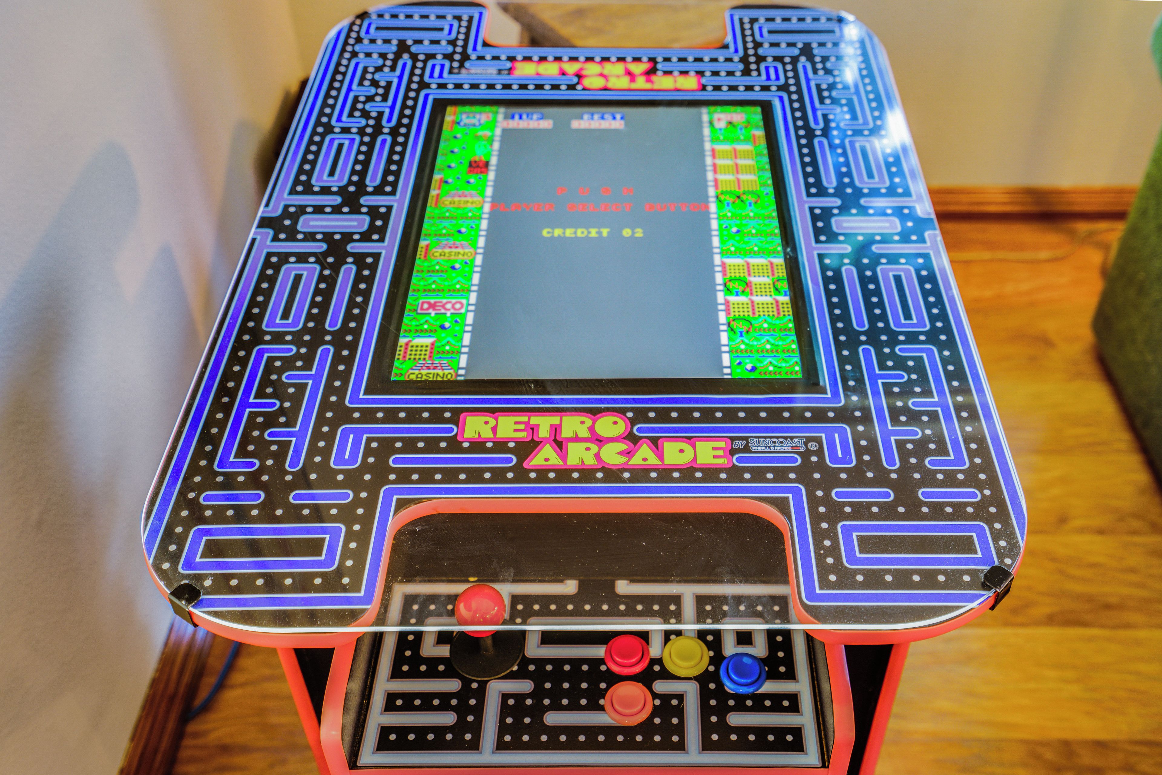 A retro arcade machine with a screen displaying game options and a joystick control panel.