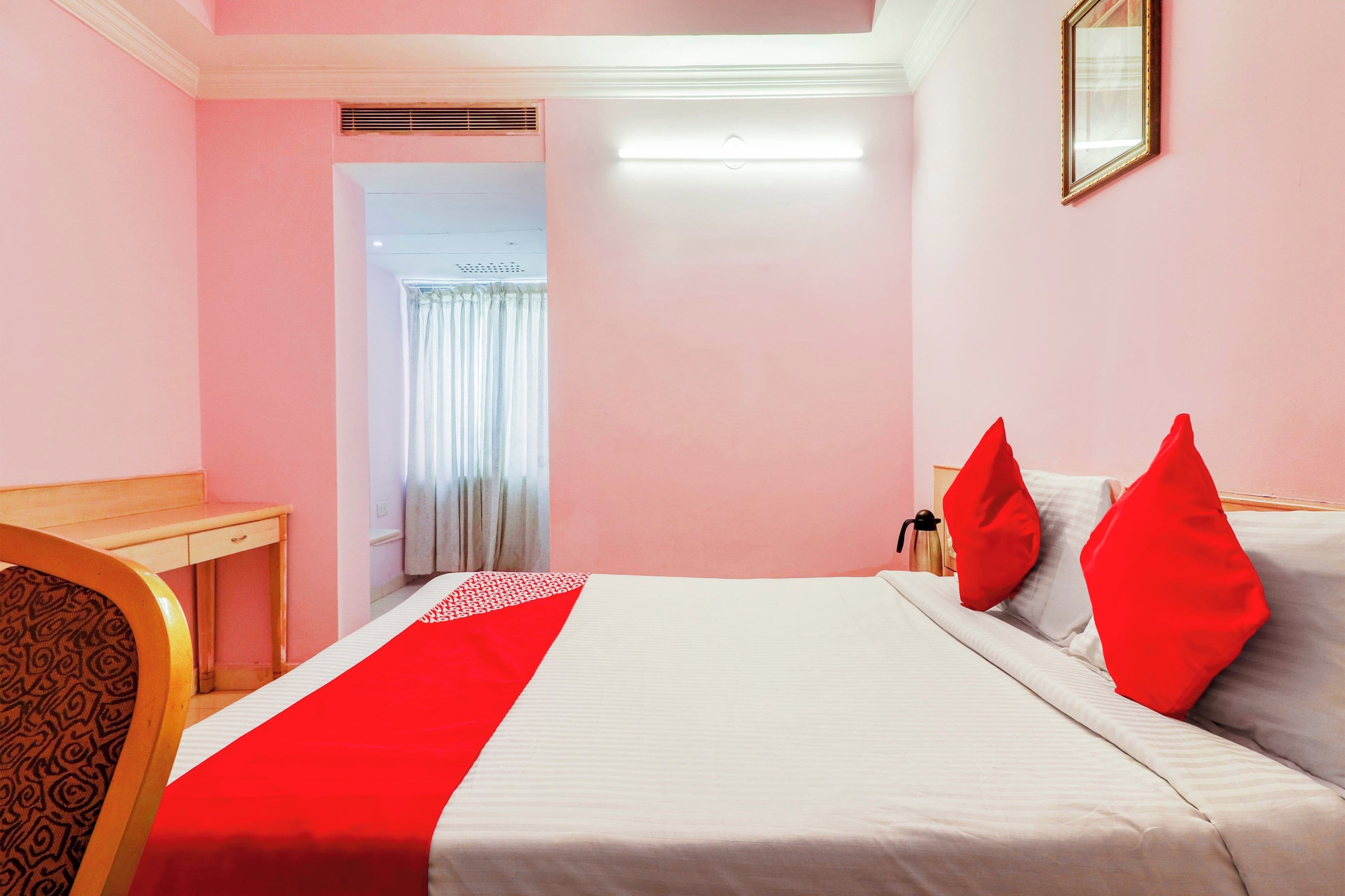 Una camera d'albergo con un letto, una scrivania e una sedia.