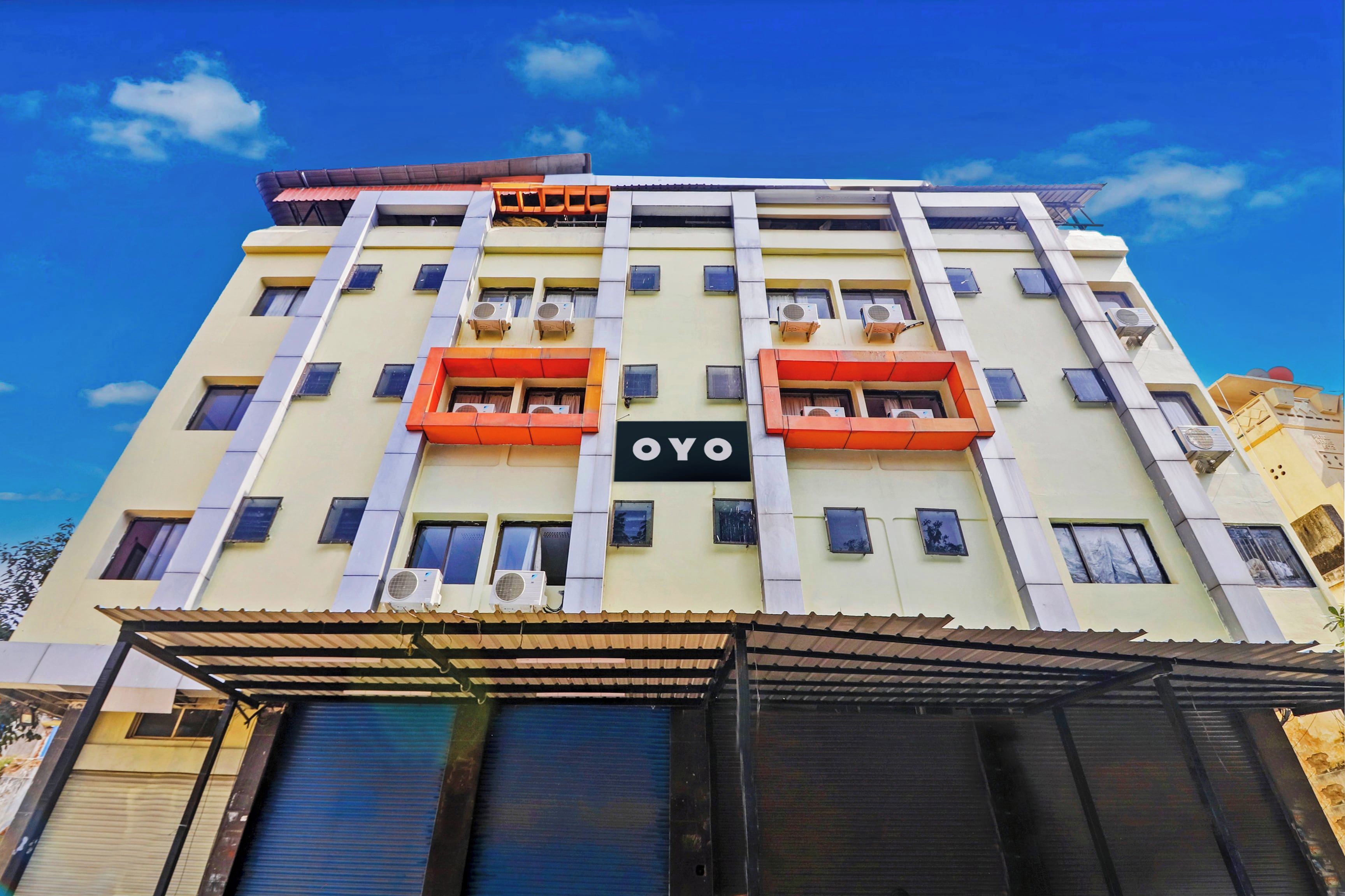 A multi-story building with balconies, air conditioning units, and a sign with the letters 'OYO'.